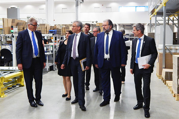 Beim Rundgang durch das Global Distribution Center von Rittal in Haiger gab Unternehmer Friedhelm Loh (l.) dem hessischen Wirtschaftsminister Al-Wazir (3.v.l.) einen Einblick in die Hochleistungslogistik für die Auslieferung von Schaltschränken und Systemkomponenten in die ganze Welt. Begleitet wurde er von Haigers Bürgermeister Mario Schramm (5.v.l.), dem Architekten Jens Freischlad (4.v.l.) und aus dem Bereich Logistik von Rittal Andreas Nögel (r.) und Robert Fenner (2.v.r.).