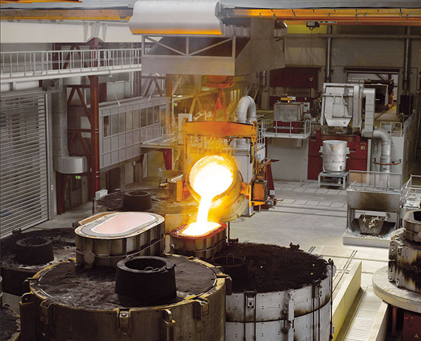 Bis zu 20 Tonnen flüssiges Eisen gelangen in nur 120 Sekunden vom Gießtümpel über das Ausgusssystem in die Form, um zu Rotornaben, Maschinenträgern, Statorglocken oder Achszapfen zu werden. (Foto: Enercon)