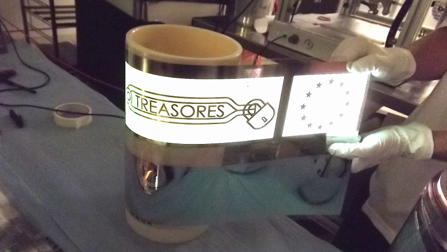 Eine flexible Lichtquelle aus organischen LED (OLED), die im Rahmen des TREASORES-Projekts entwickelt wurde. Ein Schlüsselbereich dieser Technik sind flexible Elektroden und luftundurchlässige Barriereschichten. Diese leuchtende Folie wurde am Fraunhofer FEP in Dresden in einem kostengünstigen Rolle-zu-Rolle-Prozess hergestellt. (Pressebild: Fraunhofer FEP)