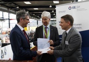 Wirtschaftsstaatssekretär Dr. Frank Nägele (Mitte) übergibt während der Messe New Energy in Husum den Förderbescheid an die Leiter des Projekts Erneuerbare Energien Schleswig-Holstein (EE.SH), Dr. Matthias Hüppauff (links) und Martin Kopp. Foto: EE.SH/ Jensen