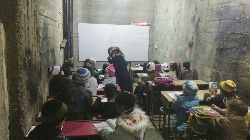 Frequent barrel bombing and shelling has forced key parts of life underground. In besieged areas across Syria there are clinics, hospitals, schools and factories running as best they can in cellars and basements, where they hope to stay safe from airstrikes. One school manages to teach more than 1,300 pupils in a web of underground classrooms. It used to operate above ground until two missiles directly hit one of the busy classrooms, killing several pupils and wounding many more. The school shut down while teachers looked for an alternative – eventually setting up a small room in a bunker, then expanding every term. Many of the children are orphaned or separated from their parents. * after a name indicates that the name has been changed to protect identity. This must be reflected in all usage. Additional Information Save the Children’s new report Childhood Under Siege highlights the experiences of hundreds of thousands of children in Syria’s besieged cities. The sieges prevent food, medicine, fuel and other vital supplies from entering and stop people from fleeing active conflict zones. Inside these cities families are struggling to survive in some of the most difficult conditions imaginable. In Syria, Save the Children has supported partners working in besieged and hard to reach areas since 2013. Together we provide food parcels to vulnerable families, support schools to keep running, repair water systems and distribute hygiene kits, and set up safe spaces and provide psychological support for children affected by bombing and siege. With our support, our partners have provided some level of assistance to more than 500,000 children in besieged and hard to reach locations in Syria. Pressebild: save the children