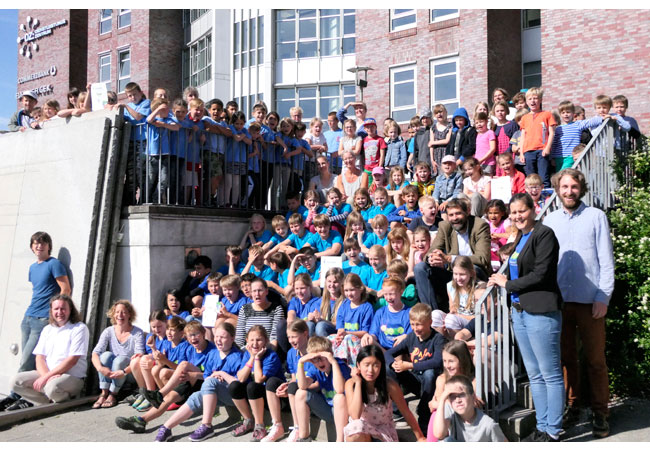 Bildunterschrift: Henning Brüggemann (Klimapakt-Vorsitzender, rechts auf der Treppe sitzend) freut sich über das große Engagement im Kreise der Projektverantwortlichen und Schülern der Falkenbergschule, Schule Friedheim, Grundschule Adelby, Paulus-Paulsen-Schule sowie der Grundschule Ramsharde. Copyright: Klimapakt Flensburg