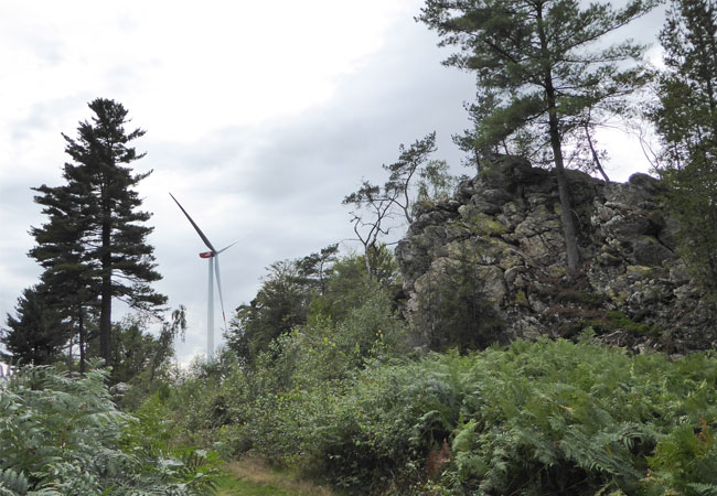Pressebild: Eine Windkraftanlage des Windparks „Berger Wacken“ hinter der namensgebenden Felsformation auf der Traumschleife „Wind, Wasser & Wacken“ / © 2017 ABO Wind AG