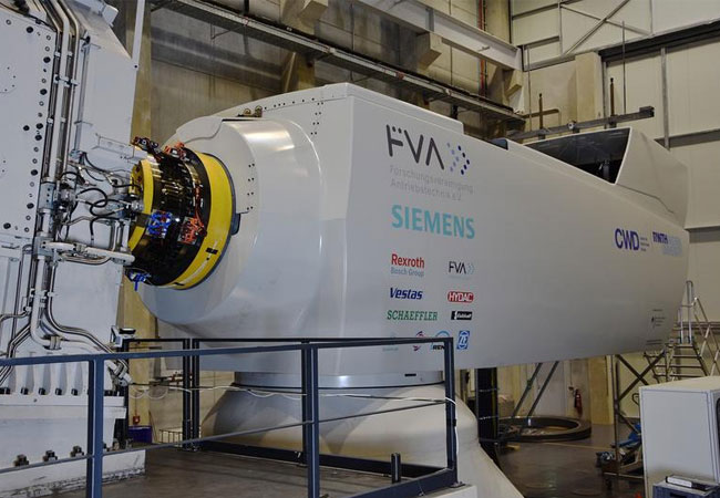 Pressebild: Der Aachener Prüfstand mit der Forschungsgondel der Forschungsvereinigung Antriebstechnik e. V. auf der rechten Seite und dem PTB Drehmomentsensor zwischen den beiden gelben Flanschen. (Abb.: Physikalisch-Technische Bundesanstalt & Rheinisch-Westfälische Hochschule Aachen)