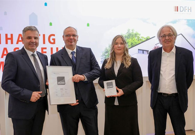 Pressebild: DGNB-Präsident Prof. Alexander Rudolphi (r.) überreichte Baufamilie Hübner das Nachhaltigkeitszertifikat. OKAL-Geschäftsführer Wilfried Bolz (l.) gratulierte der 1000. DFH-Baufamilie zum DGNB-Zertifikat für ihr Eigenheim.