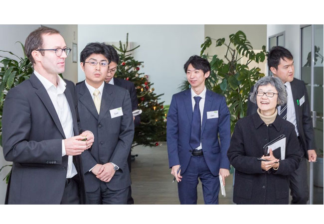 Pressebild: Beim Rundgang durch die e2m-Geschäftsräume erhielt die japanische Delegation von Marc Uhlig, Manager für Internationale Märkte, ganz praktische Einblicke in den Betrieb und die Vermarktung dezentraler Energieanlagen.