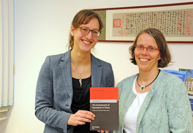 Pressebild: Sabrina Weithmann (l.) veröffentlichte am Lehrstuhl von Doris Fischer das Buch ‚The Evolvement of Standards in China – Insight from the Electric Vehicle Sector‘ zur Normung in der Elektromobilität. / Foto: Corinna Russow