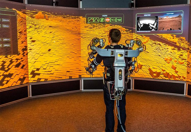 PB: Ein Operator steuert mithilfe eines Oberkörper-Exoskeletts einen Roboter in Utah (USA) von einem virtuellen Leitstand am DFKI in Bremen.