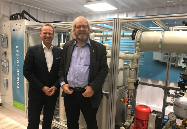 Pressebild: (v. l. n. r.) Frank Zimmermann, Geschäftsführer H-TEC SYSTEMS, und Reinhard Christiansen, Geschäftsführer Windpark Ellhöft, vor dem Demo-Modell des PEM-Elektrolyseurs ME 100/350 auf der WindEnergy Hamburg 2018. / Foto/Bildrechte: H-TEC SYSTEMS