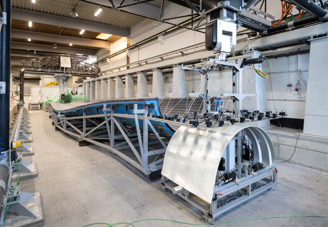 Pressebild: © Jan Meier Vorgeschnittene Glasfasergelege werden zur Vorfertigung des Wurzeleinlegers automatisiert auf eine Positiv-Form abgelegt.