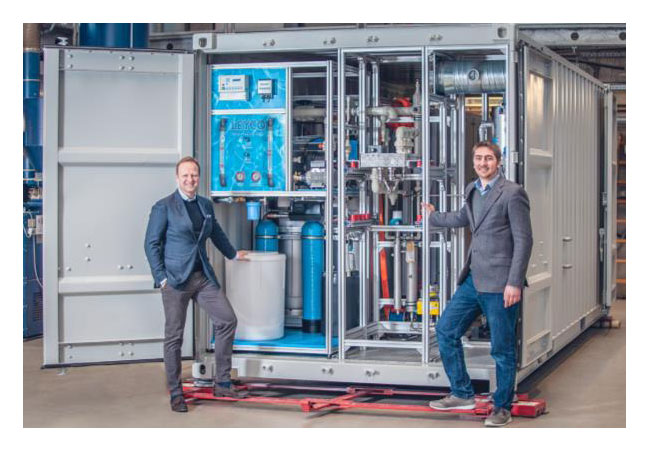 Bildunterschrift: Die Produktion bei H-TEC SYSTEMS läuft: Die Geschäftsführer Frank Zimmermann und Dr. Joachim Herrmann (von links) gewähren einen Einblick in einen im Bau befindlichen PEM-Elektrolyseur aus der Serie ME 100/350. / Foto/Bildrechte: H-TEC SYSTEMS, zur honorarfreien Nutzung