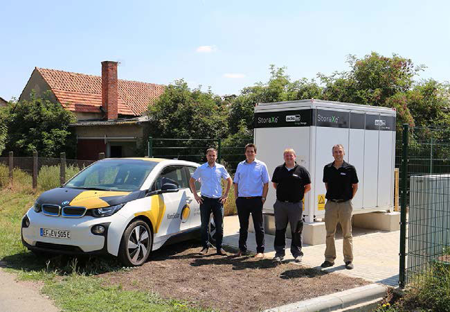 PM: Mitarbeiter von KomSolar, TEAG und ADS-TEC (v.l.n.r.) vor dem Outdoor-Batteriesystem „PowerBooster“ in Großrettbach Foto: KomSolar