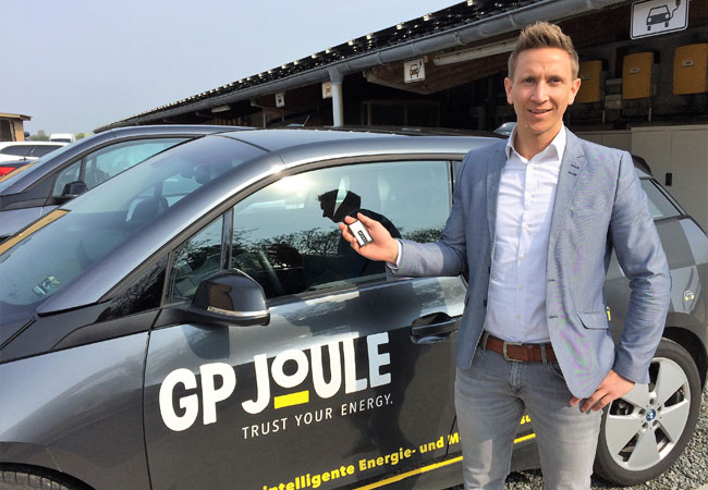 PB: Bildunterschrift: Torben Jöns, Marketing- und Vertriebsleiter von GP JOULE CONNECT sowie Vorsitzender der Landesvertretung Schleswig-Holstein des Bundesverbands eMobilität (BEM), zeigt den nicht einmal handtellergroßen GPS-Logger. Dieser ist der digitale Kernbaustein in der E-Fuhrpark-Analyse von GP JOULE CONNECT, um den individuellen Mobilitätsbedarf des künftigen E-Flottenbetreibers auf Basis der aktuellen Nutzung der Dienstfahrzeuge zu ermitteln. / Bildrechte: GP JOULE