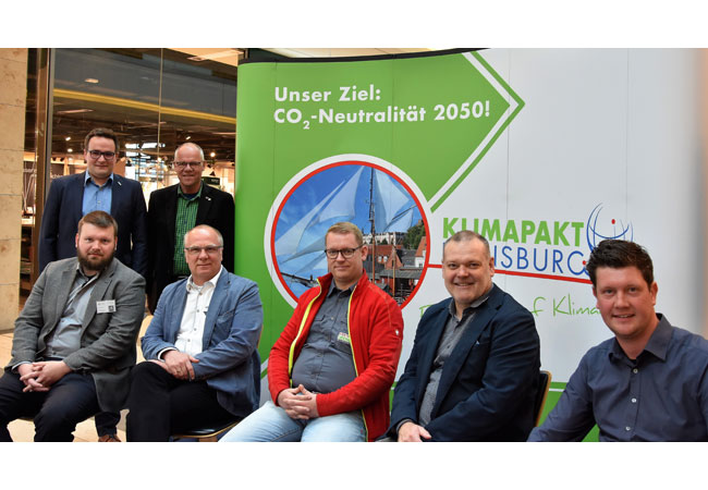 PB: Bildunterschrift: Sie diskutierten öffentlich zum Thema „Mobilität der Zukunft“: Jens Sandmeier (WTSH), Hannes Fuhrig (Stadtpräsident) (stehend, v.l.n.r.) sowie Alexander Fischer (Green TEC Campus), Oliver Rein (Stadtwerke Flensburg), Jan Obenauer (Elektro Obenauer), Paul Hemkentokrax (Aktiv Bus) und Marco Bartelsen (Windpark Ellhöft) (v.l.n.r.).