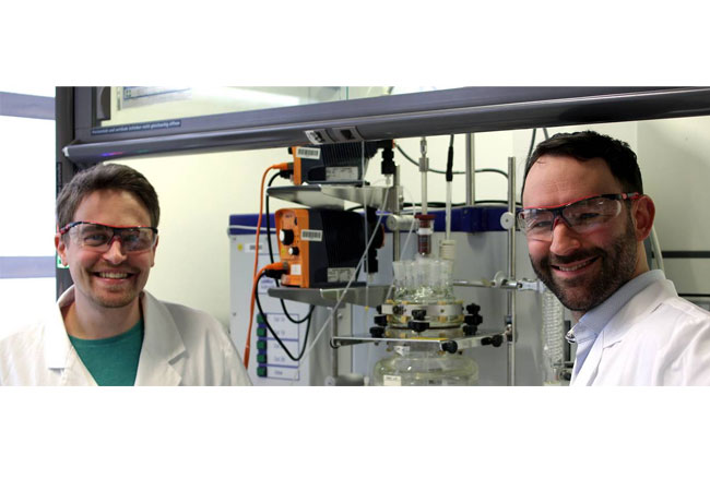 PB: Die beiden Autoren, Paul Stockmann und Dr. Daniel Van Opdenbosch, mit dem Reaktor, in dem das polymerisationsfähigen Monomer aus dem Naturstoff 3-Caren hergestellt wurde. Bild: C. Zollfrank / TUM