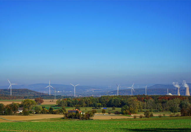 PB: Bildunterschrift: Alte und neue Energiewelt - Der Windpark Emmerthal steht in Sichtweite zum Kernkraftwerk Grohnde, das mit dem Atomausstieg spätestens Ende 2021 abgeschaltet wird. / Bildquelle: Rolf Sander