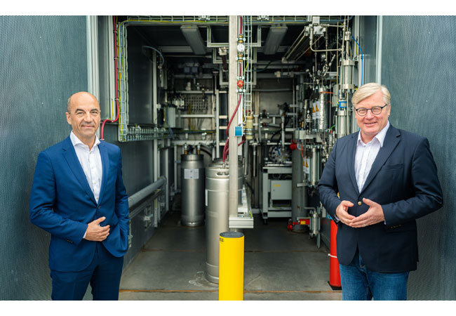 PresseFoto: EWE-Vorstandsvorsitzender Stefan Dohler (links) und Wirtschaftsminister Dr. Bernd Althusmann vor dem Elektrolyseur in Huntorf. (EWE AG/Mohssen Assanimoghaddam)
