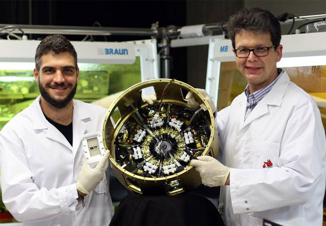 PB: Prof. Dr. Peter Müller-Buschbaum (rechts) und Erstautor Lennart K. Reb (links) im Labor der Professur für Funktionelle Materialien der Technischen Universität München mit dem Nutzlastmodul „Organische und hybride Solarzellen im Weltraum“ (OHSCIS). Bild: Wei Chen / TUM