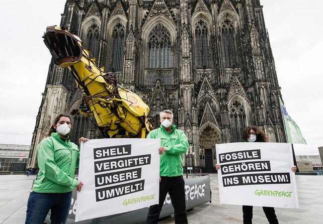 PB: Greenpeace Protest against Shell in Cologne Greenpeace activists are demonstrating in front of the Cologne Cathedral against the Shell Rhineland refinery. The Activists carry banners that Read "SHELL VERGIFTET UNSERE UMWELT!" (SHELL POISONS OUR ENVIRONMENT) and "FOSSILE GEHÖREN INS MUSEUM" (FOSSILS BELONG IN MUSEUMS). Greenpeace demonstrates simultaneously in the North Sea with the Greenpeace ship Esperanza in the Brent oil field. In April, a leak at the refinery contaminated the soil and groundwater with hundreds of thousands of liters of oil. In addition, the company plans to leave parts of four old oil platforms with 11,000 tons of oil to rot in the North Sea.