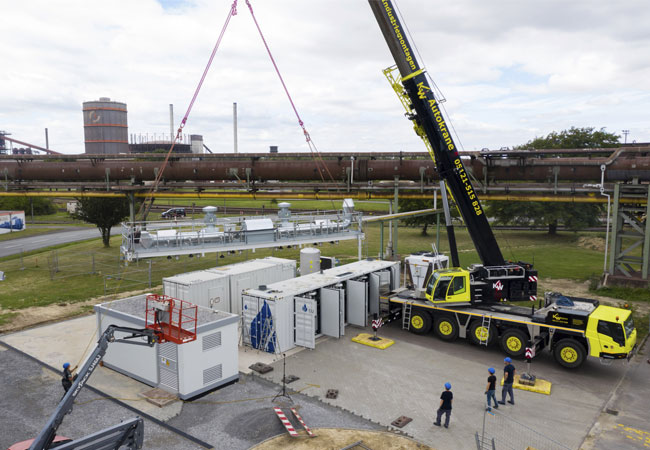 PB: Der weltweit leistungsstärkste Hochtemperaturelektrolyseur wird in Salzgitter angeliefert. Die PTB und die Salzgitter Flachstahl GmbH arbeiten zusammen, um eine präzise Mengenmesstechnik für den damit produzierten Wasserstoff zu entwickeln. (Foto: Salzgitter AG)