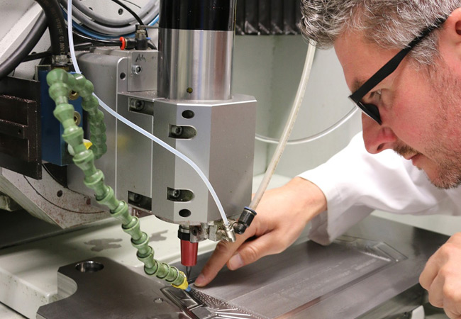 PB: Udo Eckert, Gruppenleiter Mikrosystemfertigung, aus der Abteilung Funktionsoberflächen/Mikrofertigung am Fraunhofer IWU prüft im Mikro-Bearbeitungszentrum des IWU die Finish-Bearbeitung eines gefrästen Werkzeugs für den Einsatz bei der Bipolarplattenfertigung für Brennstoffzellen. / © Fraunhofer IWU