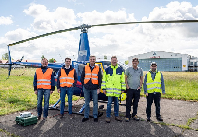 PB: Personen auf dem Gruppenbild (von links): Lars Meyer (Projektmanagement badenovaWÄRMEPLUS), Simon Laub (Gesamtprojektleiter Tiefengeothermie badenovaWÄRMEPLUS), Klaus Preiser (Geschäftsführer badenovaWÄRMEPLUS), Klaus Brauch (Geschäftsführer terratec Geophysical Services, Heitersheim), Kai Naujokat (Geschäftsführer Helikopter Training + Charter, HTC aus Donauseschingen) und Marcos Grazia (Geologe Fa. terratec).