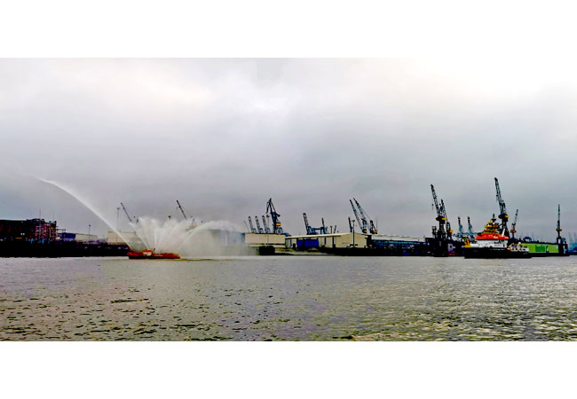 VWFS ATAIR zu Gast in Hamburg Hamburg, 16.09.2021 Vom 16. bis 17. September 2021 liegt das Vermessungs-, Wracksuch und Forschungsschiff (/VWFS) ATAIR des Bundesamtes für Seeschifffahrt und Hydrographie (BSH) an der Überseebrücke in Hamburg. Das VWFS ATAIR ist mit 75 Meter Länge und rund 17 Meter Breite das größte Schiff der BSH-Flotte. Im September 2020 übergab die Fassmer Werft das Schiff dem BSH. Im April stellte der Bundesminister für Verkehr und digitale Infrastruktur das BSH-Flaggschiff offiziell in Dienst. Die ATAIR ist das erste seegängige Behördenschiff für Spezialaufgaben mit LNG-Antrieb. Sie ist mit dem Blauen Engel für energieeffizientes Design ausgestattet und als Silent-R-Schiff besonders leise unterwegs. Als erstes Forschungsschiff weltweit verfügt sie über ein dynamisches Positionierungssystem, das Probenahmen und Wrackuntersuchungen erheblich erleichtert. Sie hat einen Tiefgang von fünf Metern und eine maximale Geschwindigkeit von rund 13 Knoten. Seit Übernahme hat die ATAIR rund 14.000 Seemeilen zurückgelegt. Ihre Forschungsreisen führten sie unter anderem über die Nordsee, den Nord-Ost-Atlantik und die Shetland-Inseln, Schottland/Orkney und den Färöern über den Entenschnabel nach Sylt, Amrum, Helgoland und durch den Nordostseekanal über die Kieler Bucht, Schleimünde, Arkona nach Rostock. Zu ihren meereskundlichen Forschungsaufgaben gehören Messungen von Salzgehalt, Druck, Temperatur, die Entnahme von Wasserproben in verschiedenen Tiefen, die Prüfung der Sichtweite im Wasser und die Auslegung von sogenannten Neuston-Netzen zur Untersuchung der Wasseroberfläche. Neuston sind die Organismen, die in einer dünnen Schicht direkt unter der Wasseroberfläche leben. In einer Fahrt in die Biskaya wurden Messketten in über 4.000 Meter Tiefe ausgelegt und ARGO-Floats ausgesetzt, treibende autonome Messgeräte. Sie sind Bestandteil von ARGO, einem internationalen mobilen Beobachtungssystem für die Weltmeere, mit dem seit dem Jahr 2000 Temperatur, Salzgehalt, Strömungen und zunehmend auch chemische und biologische Komponenten gemessen werden und in Nahe-Echtzeit der interessierten Öffentlichkeit zur Verfügung gestellt werden. Wissenschaftlerinnen und Wissenschaftler an Bord plausibilisieren die Daten direkt nach der Erhebung und übertragen sie an das Maritimen Daten Zentrum des BSH. Dort werden sie in Datenbanken eingespeist und im Rahmen von Open Data unter anderem über das GeoSeaPortal veröffentlicht. Diese Daten werden in Wissenschaft und Wirtschaft, unter anderem in der Offshore-Windindustrie, genutzt. Die ATAIR verfügt über hoch differenzierte Systeme auf ihrer Brücke. Zu den wichtigsten Aufgaben der ATAIR gehört die Vermessung der Form und der Tiefe des Meeresgrundes und die Wracksuche. Diese Arbeit legt die Basis für die Seekarten. In der Wracksuche gehen Taucher von der ATAIR aus in die Tiefe, um gerade in der Nordsee mit ihren schlechten Sichtverhältnissen von Sonaren registrierte Objekte abzutasten und mit Kameras zu untersuchen. Aus Corona-Gründen ist ein Betreten des VWFS ATAIR nur für ausgewählte Fach-Besucherinnen und -Besucher möglich. Weitere Informationen zum VWFS ATAIR: https://www.bsh.de/DE/Das_BSH/BSH-Schiffe/Atair/atair_node.html Weitere Informationen zur BSH-Flotte: https://www.bsh.de/DE/Das_BSH/BSH-Schiffe/bsh-schiffe_node.html Das BSH ist die zentrale maritime Behörde Deutschlands. An den beiden Dienstsitzen in Hamburg und Rostock sowie auf 5 Schiffen arbeiten rund 1.000 Beschäftigte aus über 100 Berufen. Im Mittelpunkt der Aufgaben stehen u.a. die Förderung, Sicherheit und Überwachung der Seeschifffahrt, Forschung und Erhebung langer Datenreihen im Bereich der Ozeanographie und Meereschemie, der Wasserstandsvorhersagedienst sowie die nautische Hydrographie, im Rahmen derer amtliche Seekarten erstellt werden. Ein in letzter Zeit stetig anwachsender Bereich ist die Zuständigkeit als Genehmigungs- und Überwachungsbehörde für Offshore-Windenergieanlagen. Als deutsche Flaggenstaatsverwaltung und Dienstleister für die maritime Wirtschaft unterstützt das BSH diese mit Genehmigungen, Haftungsbescheinigungen, Produktprüfungen, Zulassungen und Bereitstellung von Daten. Um die Vereinbarkeit von Schutz und Nutzung der Meere kontinuierlich zu verbessern und das Wissen über die Meere kontinuierlich zu vertiefen, arbeitet das BSH in der maritimen anwendungsorientierten Forschung und an der Entwicklung von Produkten und Dienstleistungen. Untersuchungen und Bereitstellung von Daten zu Seegangsmessungen in Offshore-Windparks und sowie der Aufbau von Schallmessnetzen in Nord- und Ostsee und die Bereitstellung von Daten und technischen Informationen zu Impulsschall im Meer sind Beispiele dafür. Auch die Entwicklung von Technologien zur Messung von Schiffsemissionen in der Luft gehört dazu. Mit dem BSH Systemlabor Navigation und Kommunikation steht eine Testumgebung für komplexe Navigations- und Kommunikationssysteme zur Verfügung. BU: Das Vermessungs-, Wracksuch- und Forschungsschiff ATAIR des BSH läuft in Hamburg ein - begrüßt und begleitet von der Feuerwehr