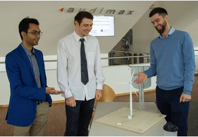 PB: Sie freuen sich über das Projektergebnis: Die Studenten Abhishek Sanyal, Flemming Ohlsen und Mikita Dzemko (v.l.n.r.) an dem Modell der speziell für Entwicklungsländer konzipierten Windenergieanlage Optimus 60.