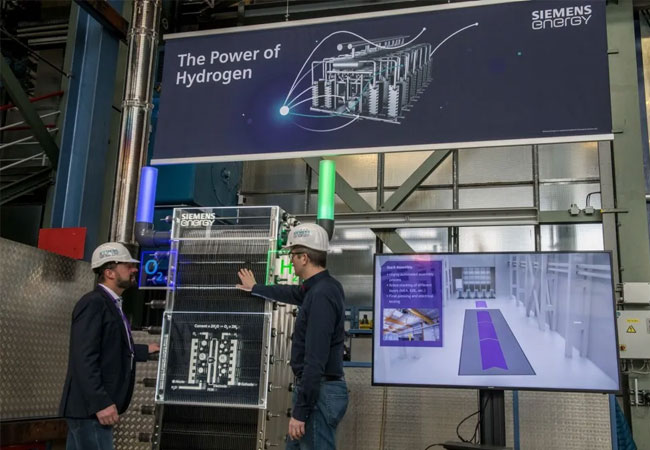 PB: Thomas Bagus (li.) wird die industrielle Fertigung der Elektrolyseure bei Siemens Energy in Berlin leiten. Derzeit plant er mit seinem Team die letzten Details zur Einrichtung der Fertigungshalle am Standort in Berlin. Die Produktion soll 2023 beginnen.