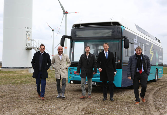 Foto: © Björn Lübbe Kurzer Wasserstoffbus-Stopp am Windpark (v.l.n.r.): Olaf Lies, Niedersächsischer Minister für Umwelt, Energie, Bauen und Klimaschutz, EWE-Chef Stefan Dohler, Jan Cyrullies, Regionalleiter Produktion DB Regio Bus Nord und Geschäftsführer der Weser-Ems Busverkehr GmbH, Maximilian Graf von Wedel, Gruppe Gödens, und Frieslands Landrat Sven Ambrosy