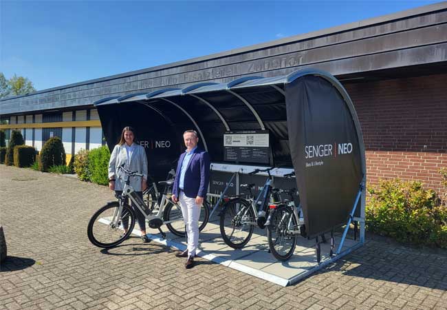 PB: Manon Dickmänken, Service Assistentin Autohaus Senger und René Scheilen, Geschäftsführer Senger NEO, neben einer E-Bike-Station (c)Senger NEO