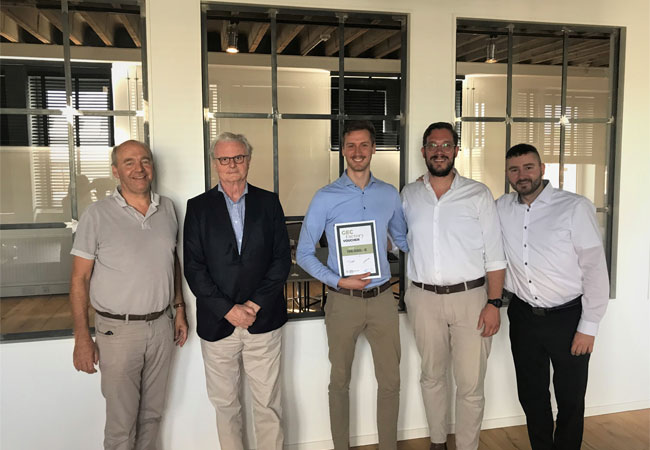 Pressebild: das Person, stehend, darstellend, Boden enthält. Automatisch generierte Beschreibung: [v.l.n.r.] Friedrich Barth (GEC), Andreas Theil (AVM), Victor J. Jürgensohn (AVM), Sebastian Gronwald (GEC), Michael Seher (AVM)