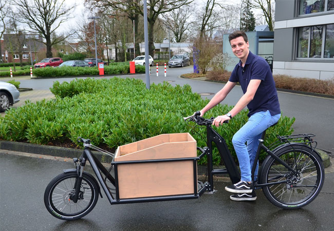 PB: Studierende am Fachbereich Maschinenbau konzipierten und konstruierten Lastenfahrräder in Zusammenarbeit mit dem Unternehmen Velo de Ville. Hier im Bild: Jannis Kuschel bei der Testfahrt mit dem ersten fertiggestellten Fahrrad im Frühjahr 2022. (Foto: FH Münster/Frederik Tebbe)