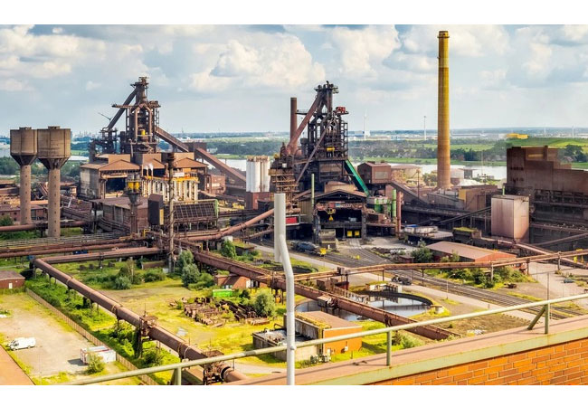 PB: Das Stahlwerk von Arcelor Mittal an der Weser in Bremen. Den Kohlenstoff in der Stahlproduktion durch Wasserstoff zu ersetzen, ist eine der vielen Aufgaben, an denen im Großforschungsprojekt hyBit gearbeitet wird. Foto: Michel Iffländer GfG/Universität Bremen