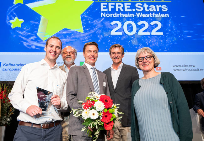 PB: S. Krebs (r.), Staatssekretär*in im Ministerium für Wirtschaft, Industrie, Klimaschutz und Energie des Landes Nordrhein-Westfalen, gratulierte dem Projektteam des Zink-Luft-Speichers (v.l.n.r): Andre Löchte von der FH Münster, Dr. Hans-Jürgen Pauling von der RECAT GmbH, Markus Kunkel von Kunkel + Partner Ingenieure GmbH sowie Projektleiter Prof. Dr. Peter Glösekötter von der FH Münster. (Foto: Udo Geisler)