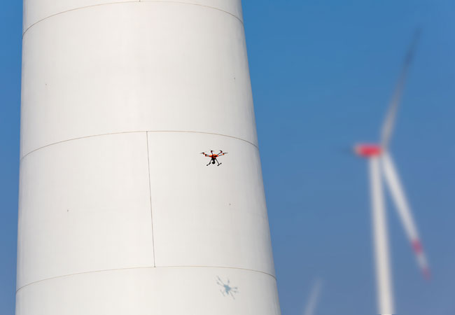 PB: In einem Pilotprojekt setzt TÜV NORD auf Drohnenunterstützung bei der sogenannten End-of-Warranty-Inspektion zum Ende der Garantie-Laufzeit. Per Drohne wird der komplette Betonturm abfotografiert; TÜV NORD-Sachverständige werten die Bilder aus. (Foto: TÜV NORD)