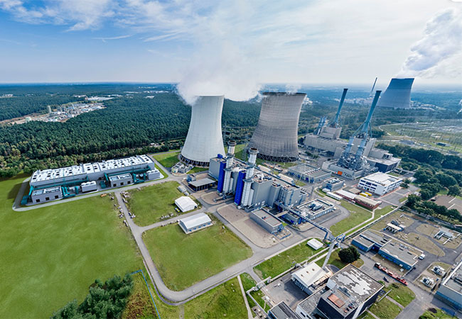PB: Das Bild zeigt das RWE Gaskraftwerk Emsland in Lingen mit einer Visualisierung des Gebäudes (links neben Kühlturm), in dem die GET H2 Elektrolyse installiert werden soll. (Bild: RWE)