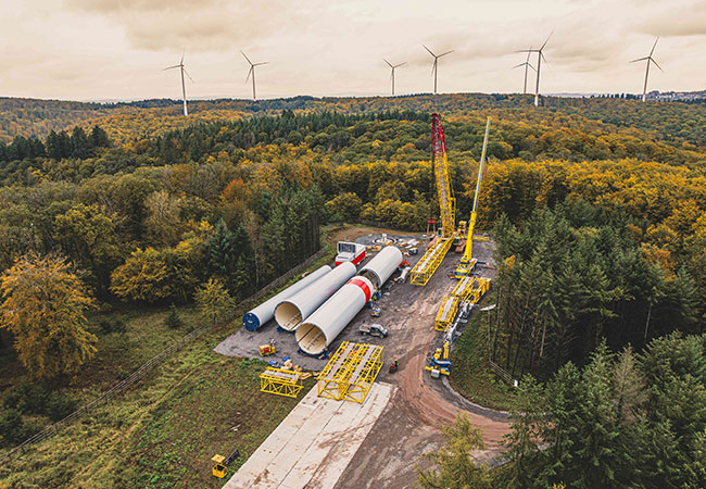 PB: Mit einem Spezialkran werden die tonnenschweren Bauteile der Windkraftanlagen zusammengesetzt / ©: Koehler-Gruppe