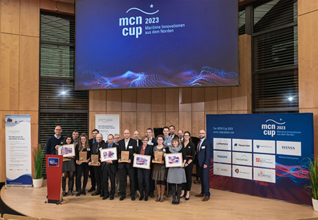 PB: MCN-Cup-Gewinner:innen 2023 mit MCN-Vorständen und den Moderierenden / ©: MCN / Marc Matthaei