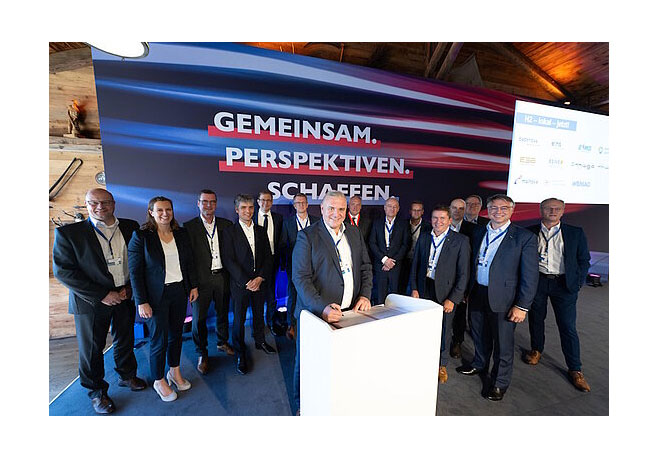 PB: Jörg Höhler (Mitte), Vorstandsmitglied der ESWE Versorgungs AG, bei der Unterzeichnung zum Kooperationsstart in München. Foto: argum / Falk Heller