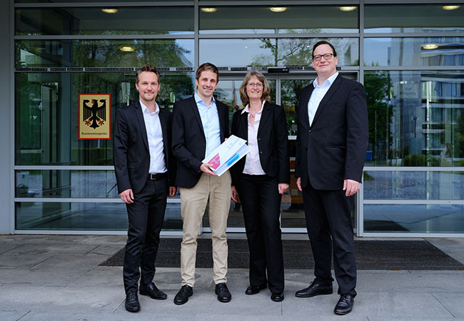 PB: Trafen sich in Bonn zur Übergabe der ersten Unterlagen im nächsten Genehmigungsschritt für Korridor B (v. l. n. r.): Fabian Hambüchen (Bundesnetzagentur), Dirk Hensen (Amprion), Ines Reichel (Bundesnetzagentur), Arndt Feldmann (Amprion). Foto: Amprion/Christopher Mick. / ©: Amprion