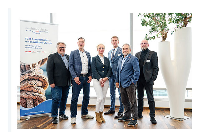 PB: MCN-Vorstand: V. l.: Holger Ritter (DRYNET), Frank Nicolai (Moore BRL), Kerstin Broocks (Guideline), Prof. Bastian Gruschka (Hochschule Bremen, blueMEC), Hans-Georg Tschupke (Die Senatorin für Wirtschaft, Häfen und Transformation Bremen), Oliver Schinzel (HSM – Hanse Ship Management). Nicht im Bild: Torben Taeger (Evac Germany) / ©: Karlis Behrens