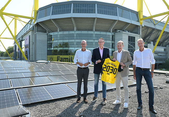 PB: v.l.n.r.: Carsten Cramer (Geschäftsführer BVB), Dr. Markus Krebber (CEO RWE AG), Hans-Joachim Watzke (Vorsitzender der Geschäftsführung BVB), Ulf Kerstin (CCO RWE Supply & Trading) vor der neuen PV-Anlage auf dem Dach der BVB-FanWelt.