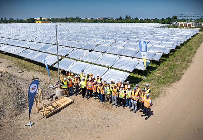 PB: Geschafft! Das stolze Team des Solarthermie-Großprojekts Leipzig West freut sich über die Montage des finalen Kollektors auf dem insgesamt 65.208 Quadratmeter großen Kollektorfeld. (Foto: Leipziger Stadtwerke)