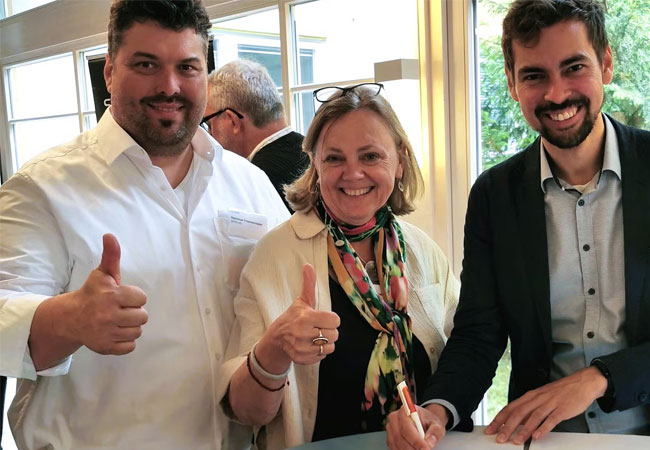 PB: Unterzeichnung des Rahmenvertrags durch Katharina Habersbrunner, Vorständin der BENG, Nepomuk Poschenrieder, Projektleiter bei der BENG, und Bürgerwerke-Vorstand Felix Schäfer während des Bürgerenergie-Konvents 2025