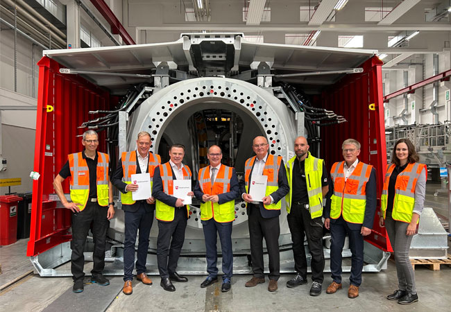 PB: (v.l.n.r.) Volker Trebesch (ENERCON Betriebsrat), Wiard Siebels (MdL Niedersachsen), Udo Bauer (ENERCONCEO), Grant Hendrik Tonne (Wirtschaftsminister Niedersachsen), Michael Jaxy (ENERCON CFO), Kevin Kebel (ENERCON Konzernbetriebsrat, Horst Feddermann (Bürgermeister Stadt Aurich), Lena Trebesch (Sales & After Sales Managerin für Norddeutschland) bei der Förderbescheidübergabe vor einer E-Gondel im ENERCON Kompetenzzentrum Mechatronic in Aurich. / ©: ENERCON