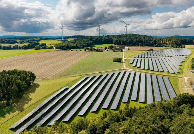 PB: Der neue Solarpark Hatzenhof und der Windpark Granswang (im Hintergrund) speisen in das nahe gelegene Umspannwerk Raitenbuch ein. / ©: Ørsted